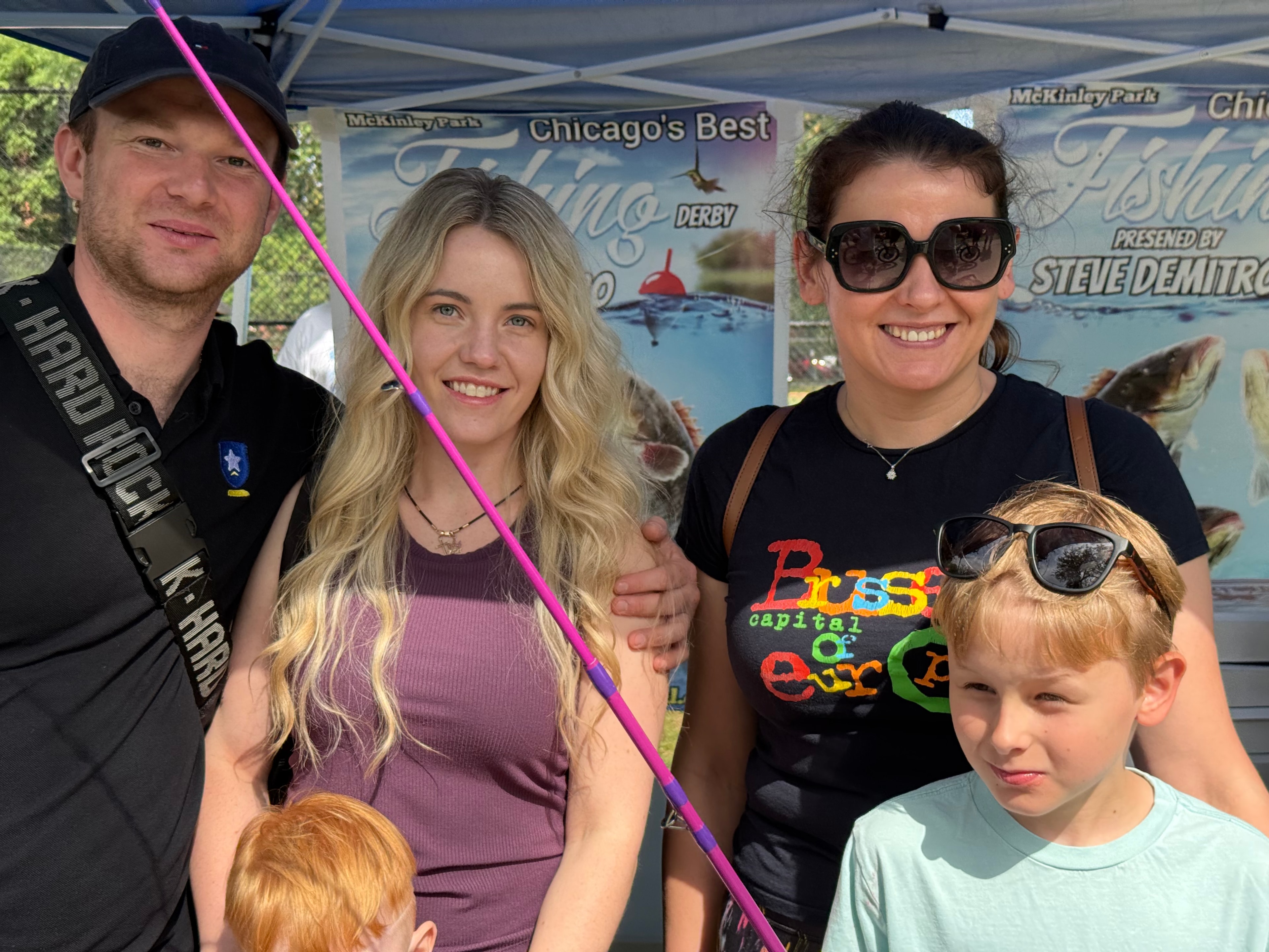 Family posing in front of the Chicago's Best Fishing Derby banner