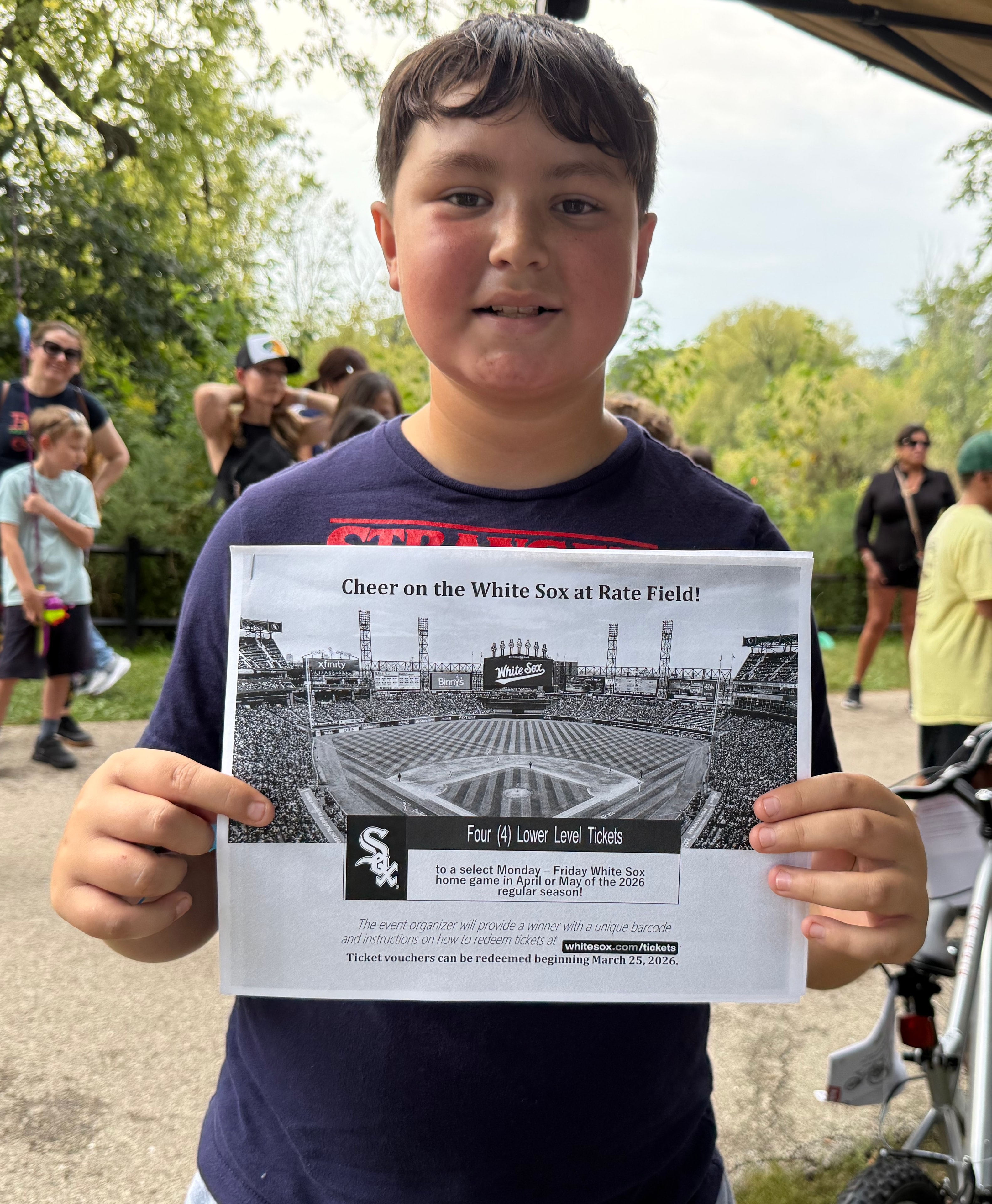 Young winner holding White Sox ticket voucher at the fishing derby